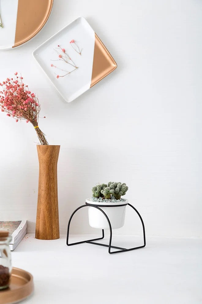 White ceramic planter with metallic stand